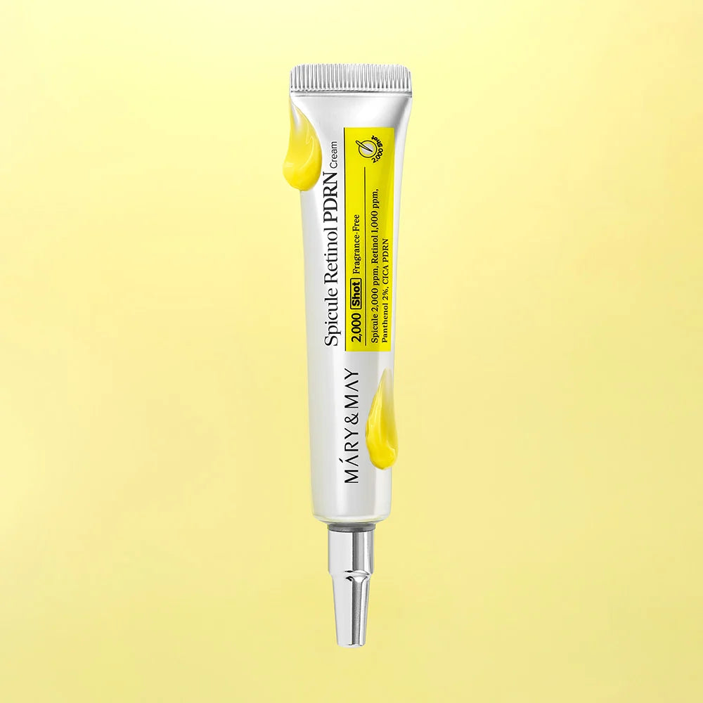 A squeeze tube of Mary&May Spicule Retinol PDRN Cream, featuring a white body with a bright yellow label and yellow cream drips, set against a soft yellow gradient background.