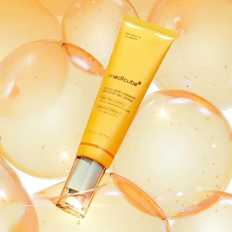 medicube eye cream kojic acid on a background of orange and yellow spheres