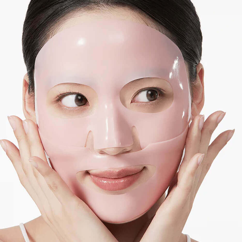Woman wearing a Anua Peach 70 + Niacin brightening collagen facial mask with a plain background