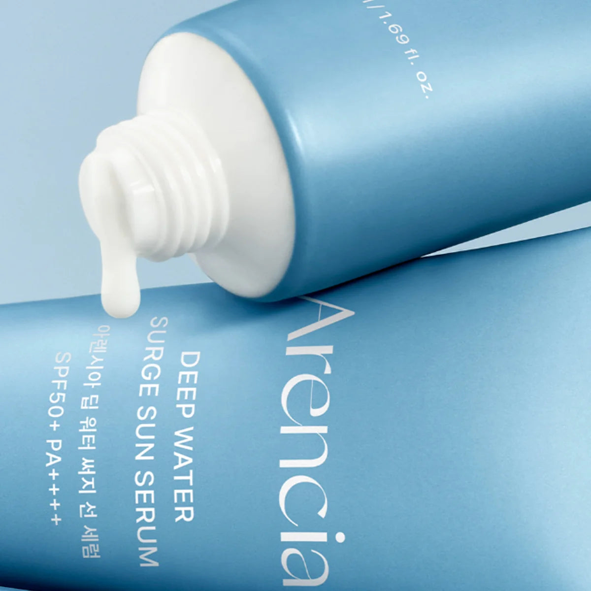 Blue tube of Arenicia Deep Water Surge Sun Serum with white cap on a light blue background