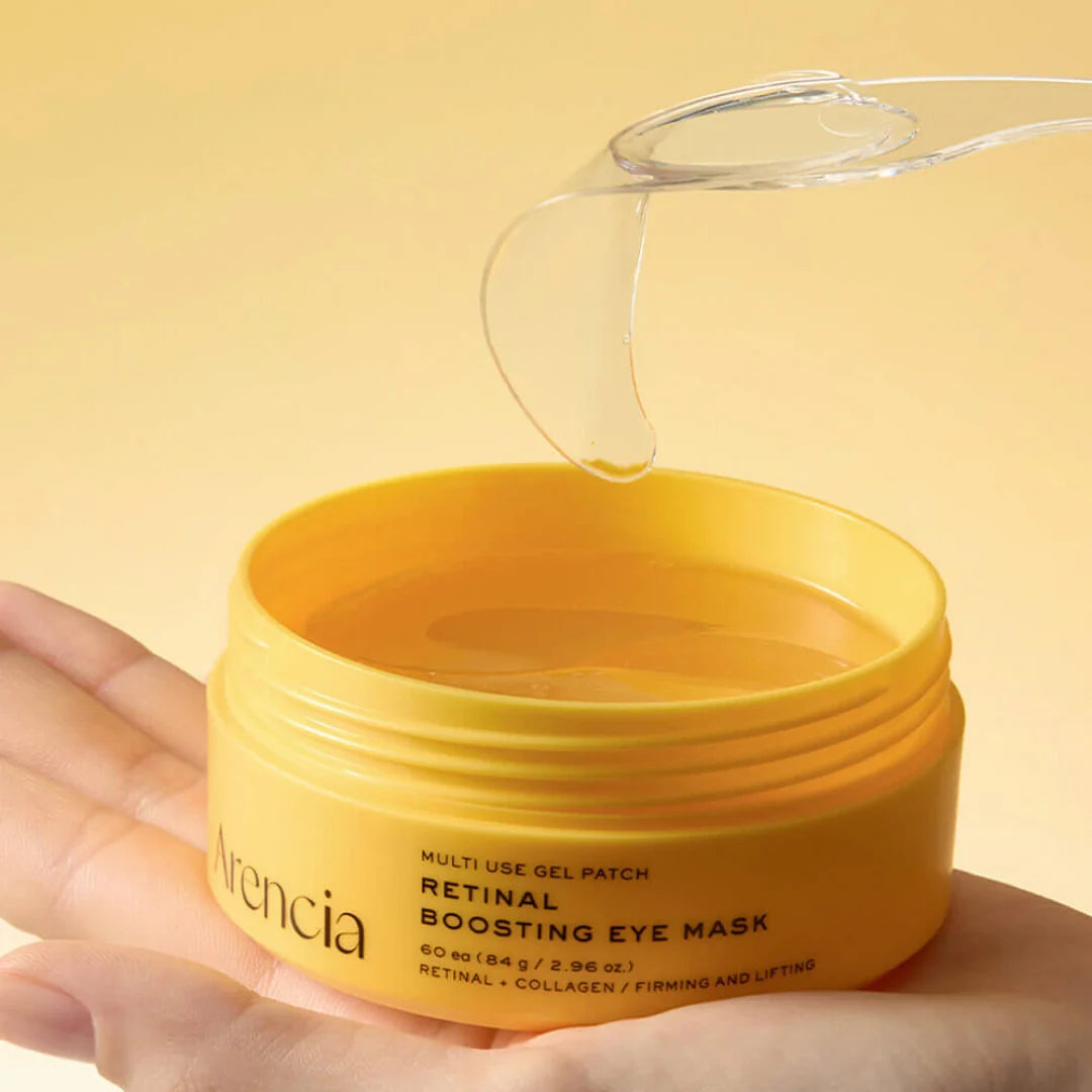 Arencia Retinal Boosting Eye Mask with a hand holding it against a yellow background