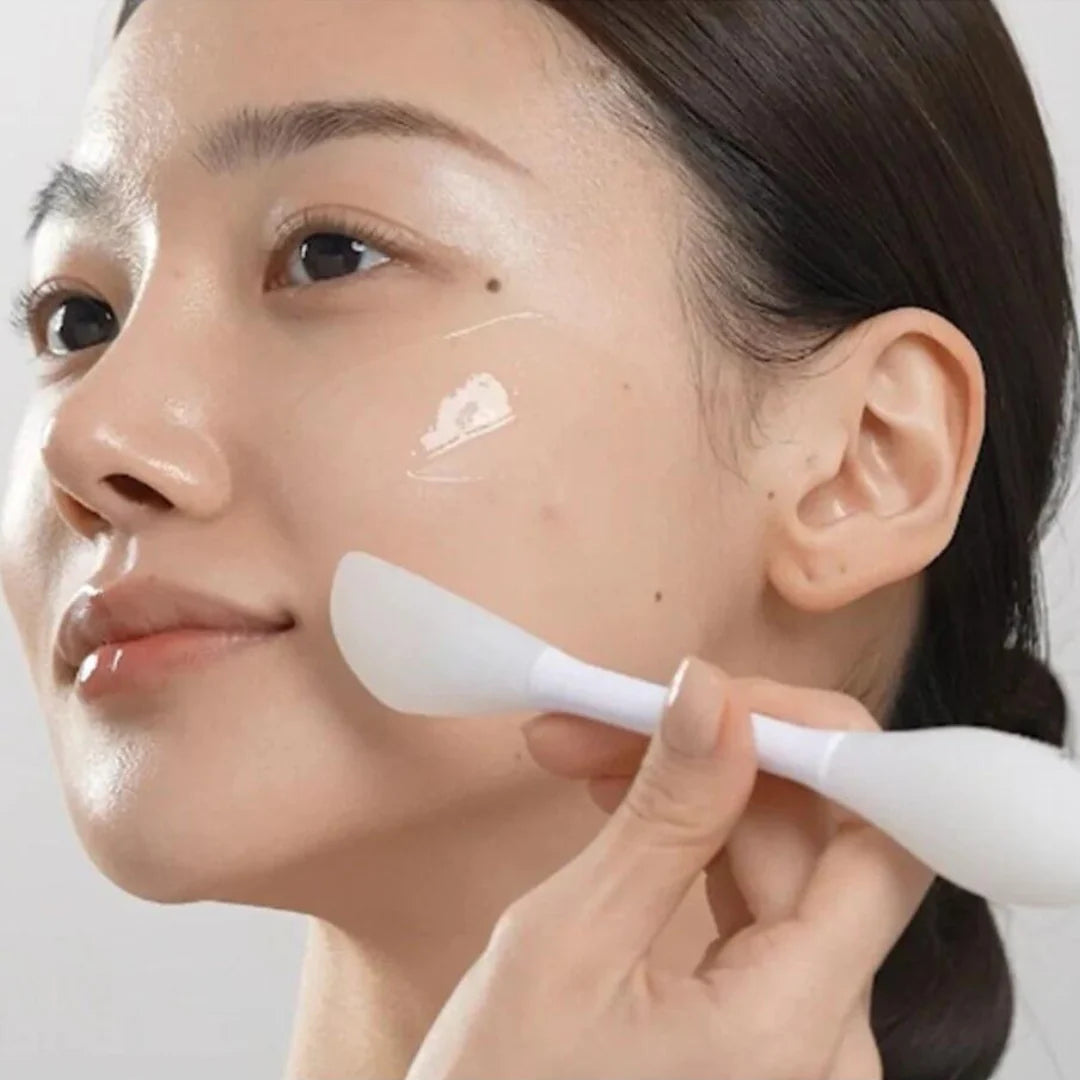 Person applying Medicube, Collagen Night Wrapping Mask to face with a white applicator