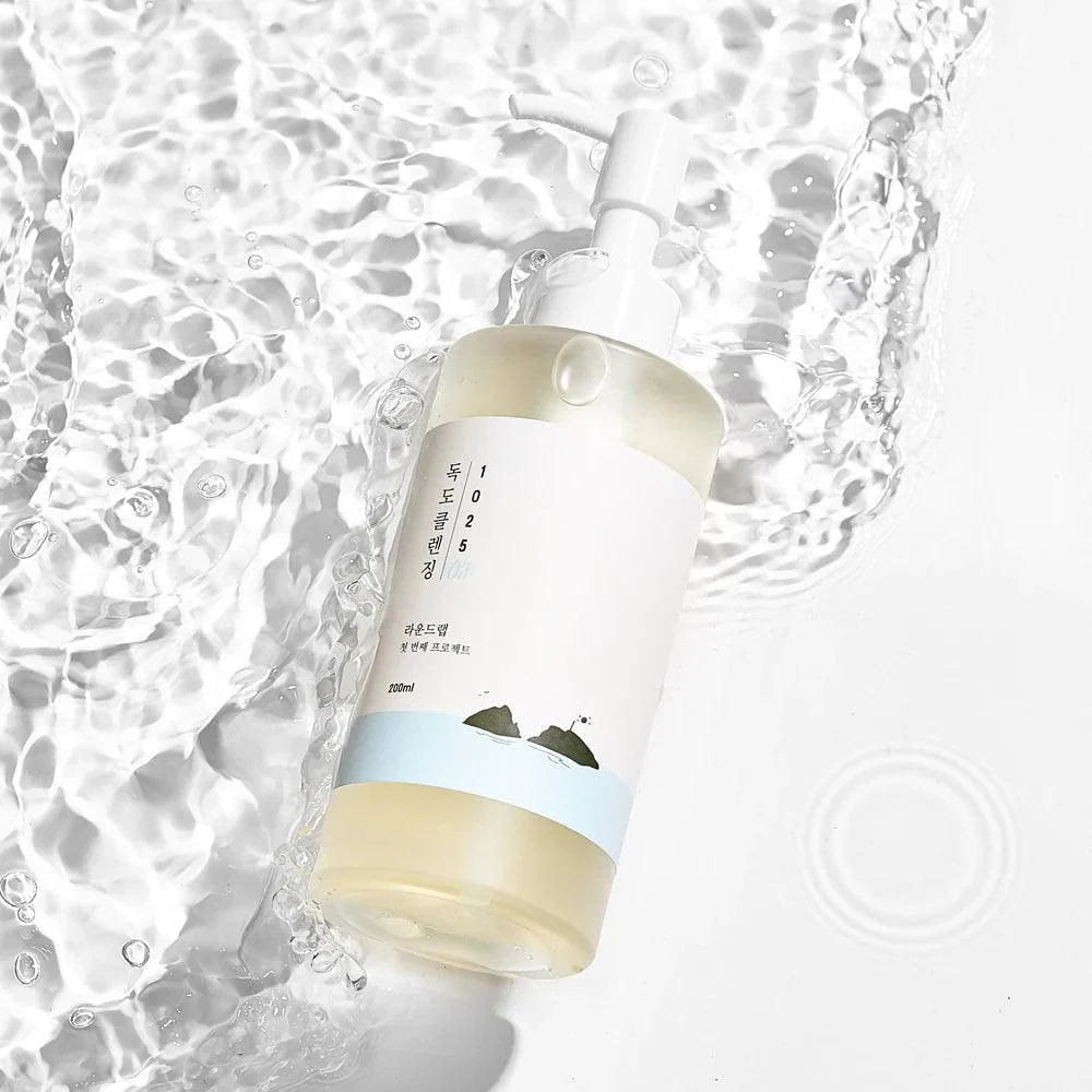 Round Lab 1025 Dokdo Cleansing Oil set against a background of rippling water.