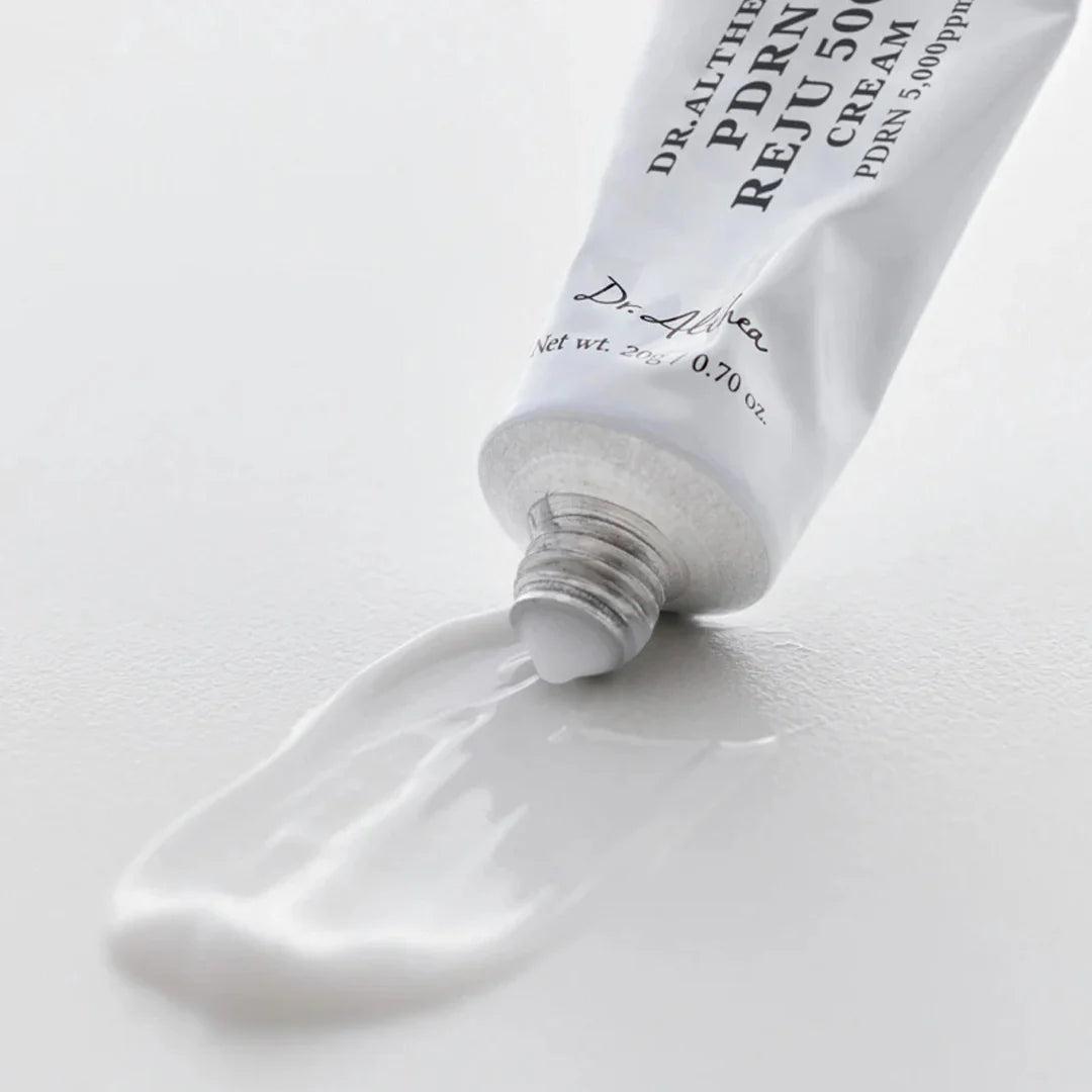 Tube of Dr. Althea, PDRN Reju 5000 Cream with cream spilling out on a white background