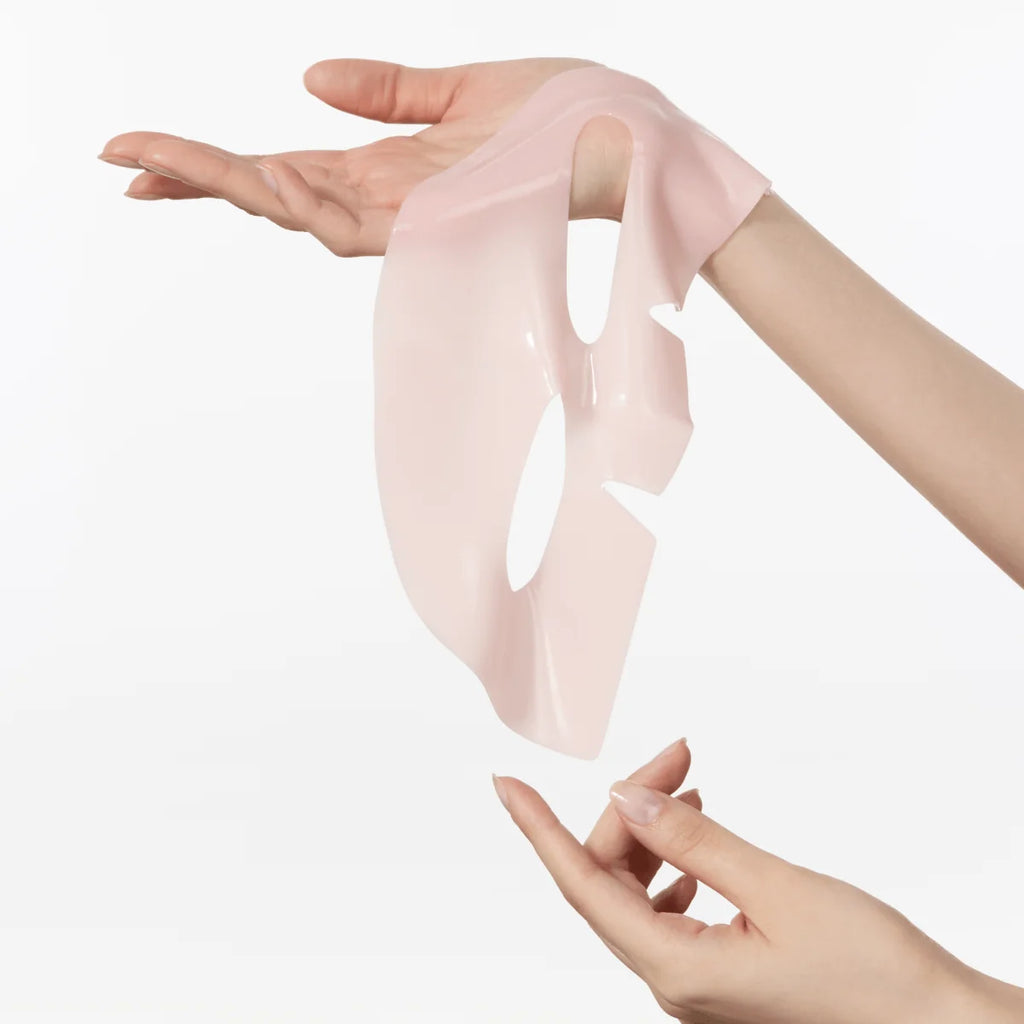 Anua Peach 70 + Niacin brightening collagen facial mask being stretched by hands on a white background