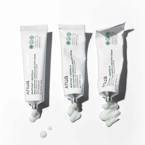 Three tubes of Anua Heartleaf Centella Red Spot Cream  with visible droplets on a white background
