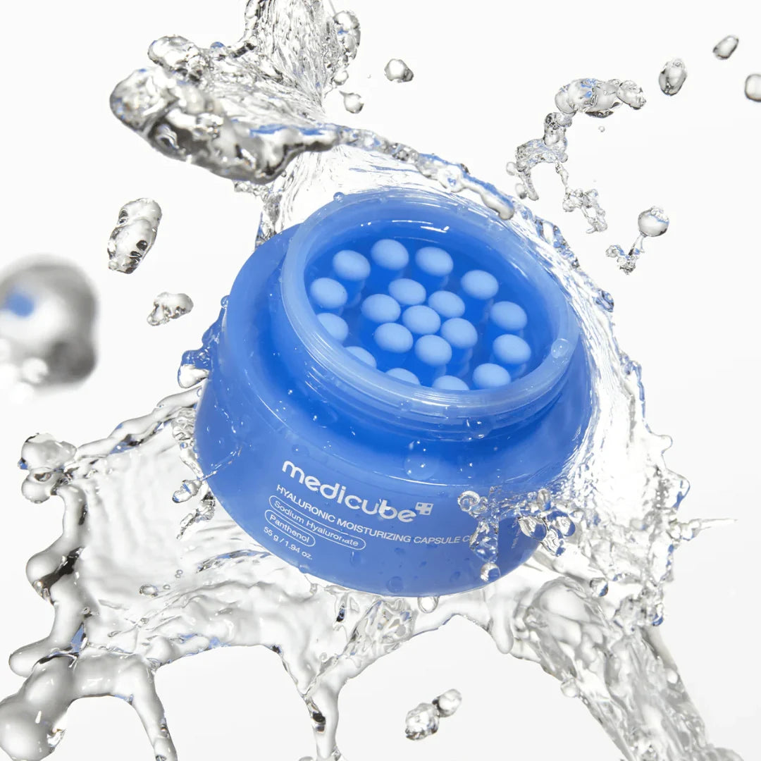 Blue jar of Medicube Hyaluronic Moisturizing Capsule Cream with water splashes on a white background