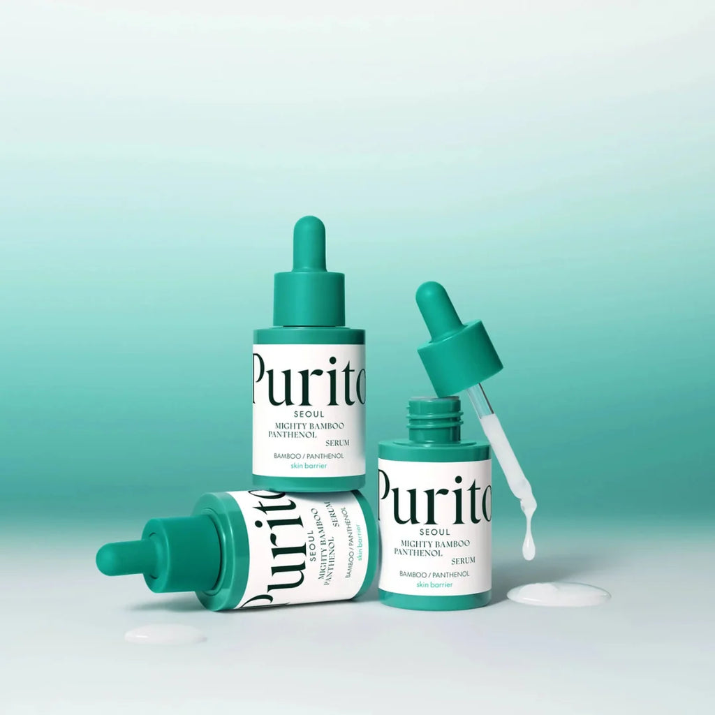 Three Putiyo Mighty Bamboo Panthenol Serum bottles in a teal and white color scheme, arranged on a clean white surface with a soft teal gradient background. One bottle is upright, one is lying on its side, and one dropper is open with liquid dripping onto the surface.