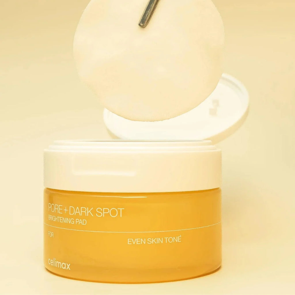 Cosmetic container labeled 'Celimax Pore + Dark Spot Brightening Face Pads on a beige background