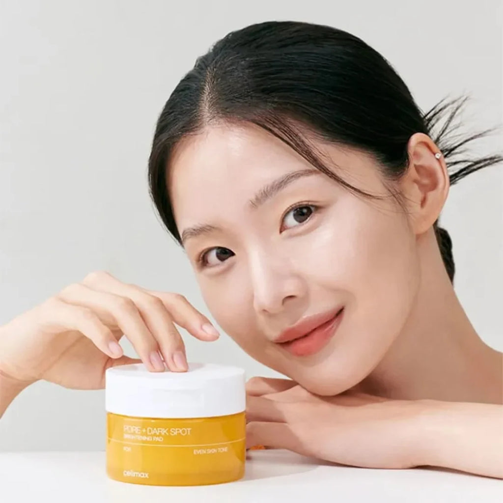Woman holding Celimax Pore + Dark Spot Brightening Face Pads with a plain background