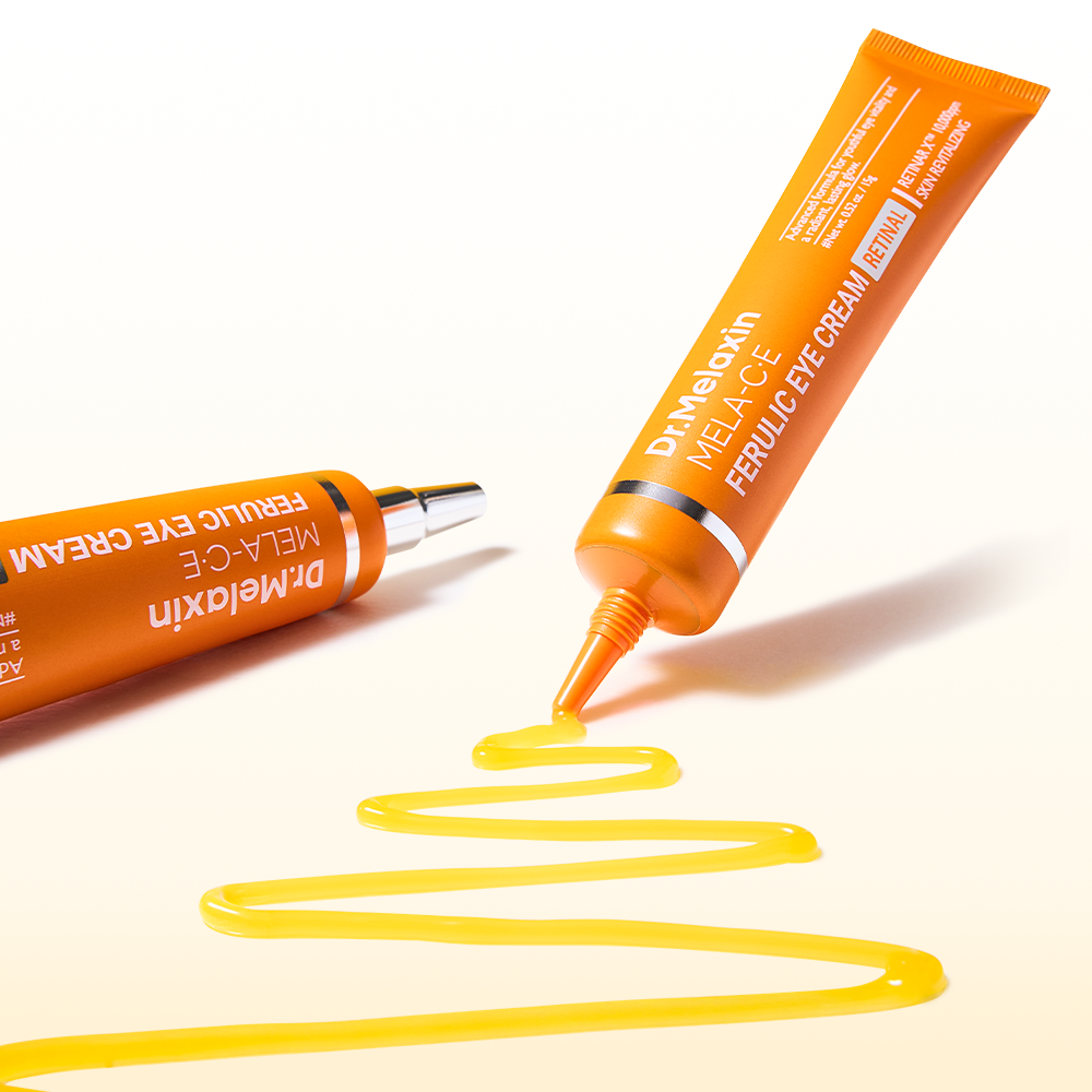 Two orange tubes of Dr.Melaxin Mela-CE Ferulic Eye Cream are shown on a white background, one lying horizontally and one standing diagonally, with bright yellow cream squiggled in a decorative pattern below.