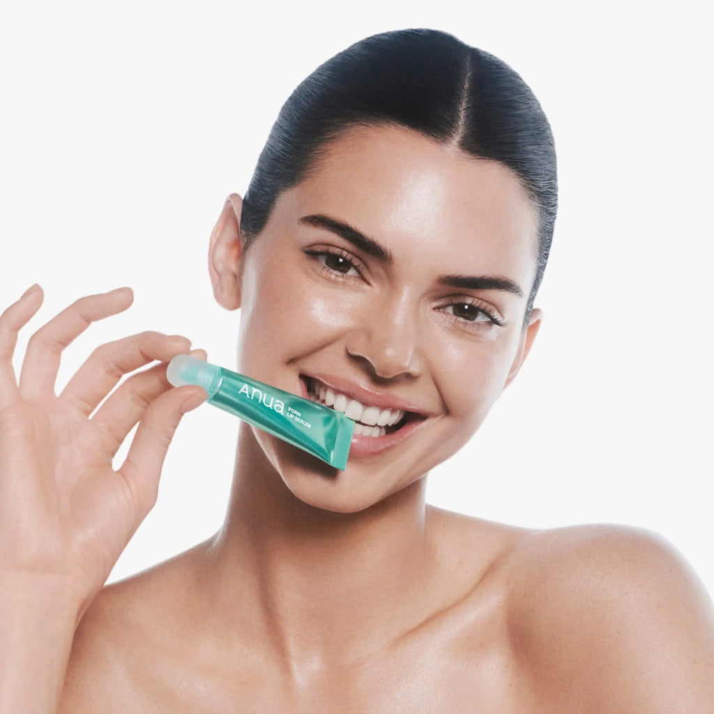 kendall jenner  holding anua pdrn lip serum with a white background