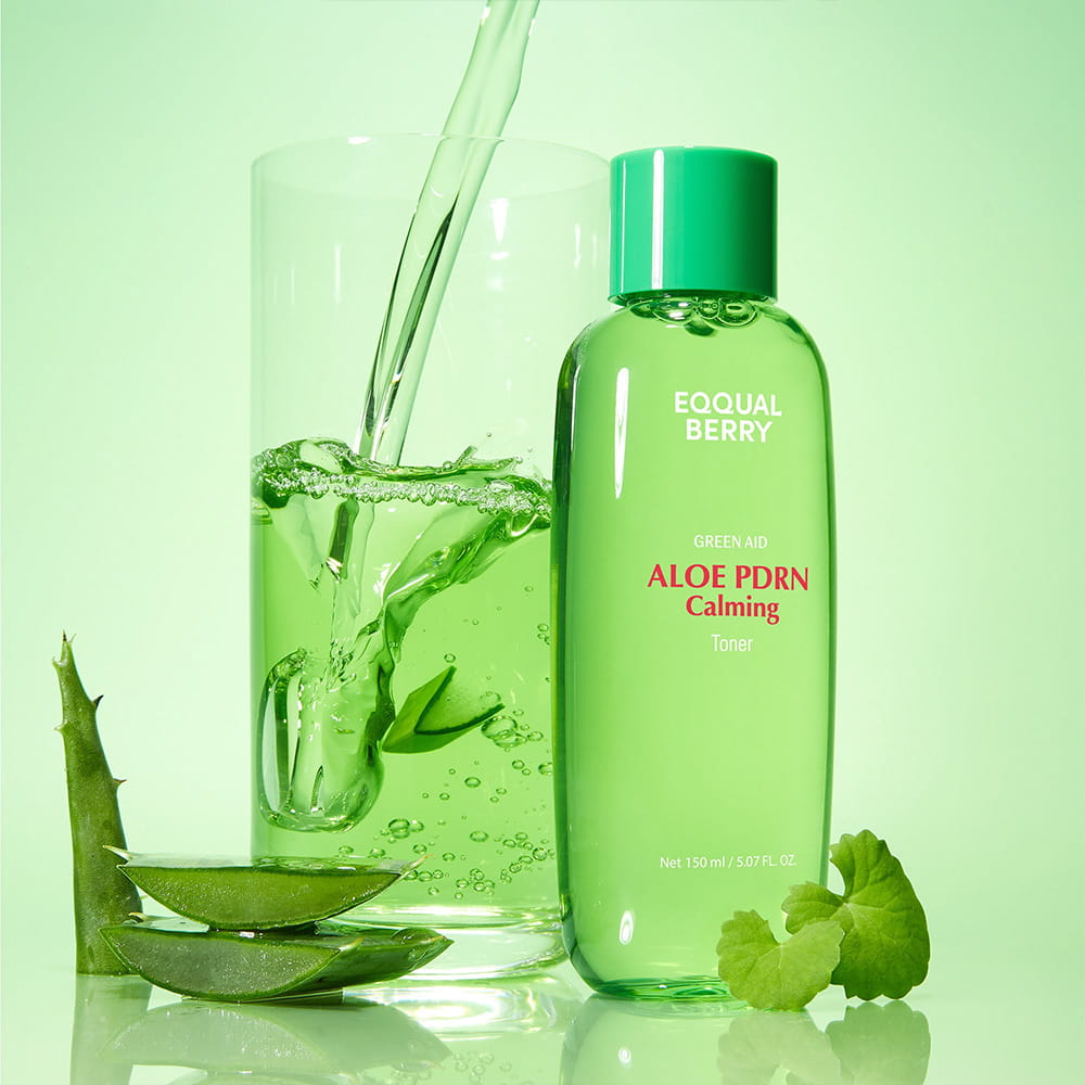 A bottle of EQQUALBERRY Aloe PDRN Calming Toner  stands next to a glass of green liquid with a stream pouring into it, styled with aloe vera slices and leaves on a light green background.